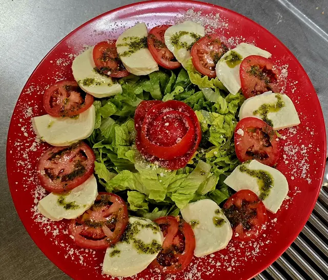 Caprese salad with fresh mozzarella, tomato and pesto