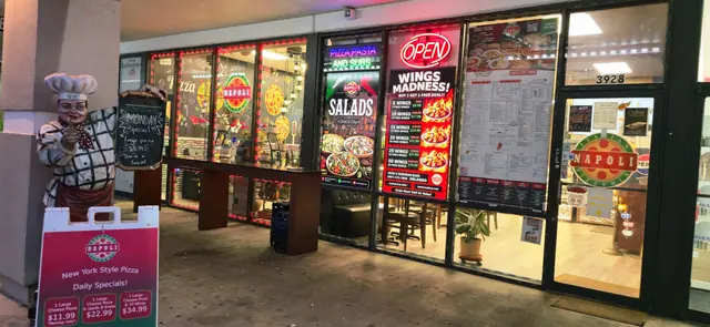 Front entrance at night with the menu board and chef statue