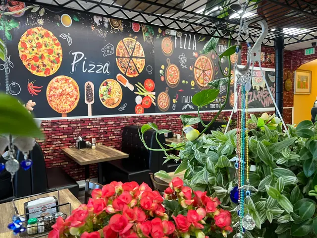 Red roses in front of the pizza mural wall